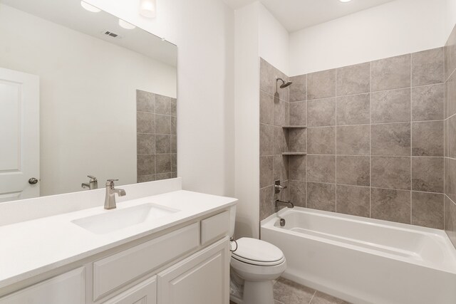 full bathroom featuring vanity, tile patterned flooring, toilet, and tiled shower / bath