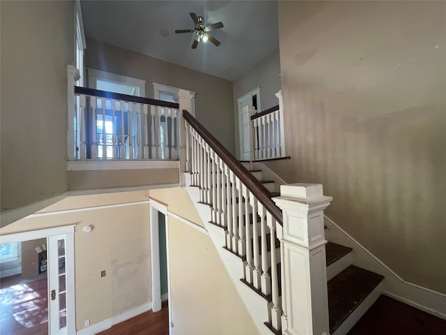 staircase with hardwood / wood-style floors and ceiling fan