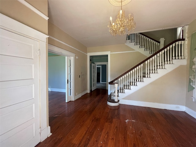 foyer entrance featuring dark hardwood / wood-style floors and an inviting chandelier