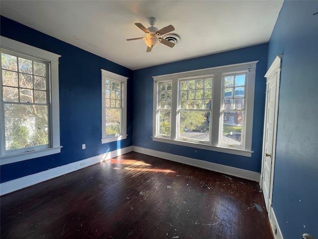 unfurnished room featuring dark hardwood / wood-style floors, a healthy amount of sunlight, and ceiling fan