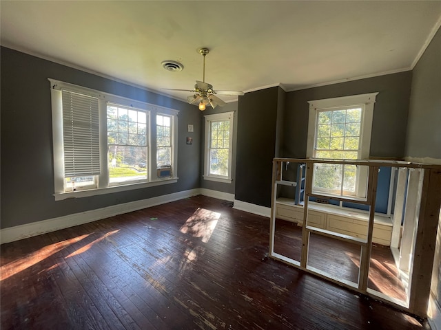 empty room featuring ceiling fan, a healthy amount of sunlight, ornamental molding, and dark wood-type flooring