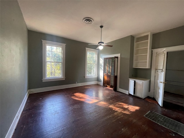 unfurnished dining area featuring dark wood-type flooring and ceiling fan