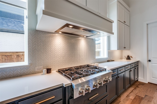 kitchen featuring white cabinets, tasteful backsplash, light hardwood / wood-style flooring, and stainless steel gas stovetop