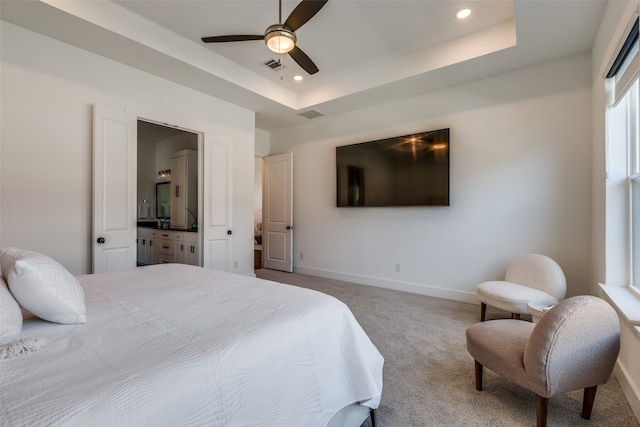 bedroom with carpet floors, a tray ceiling, and ceiling fan