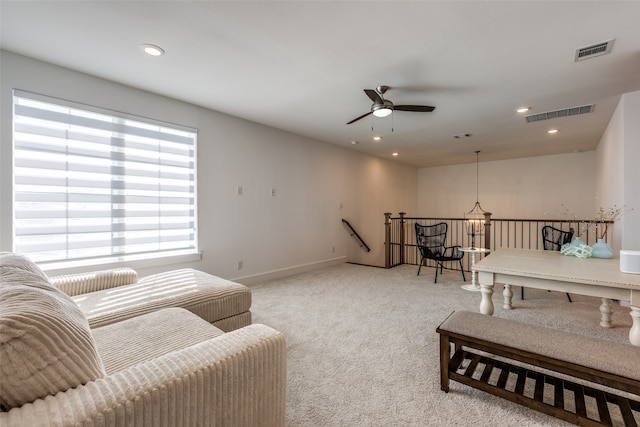 carpeted living room with ceiling fan