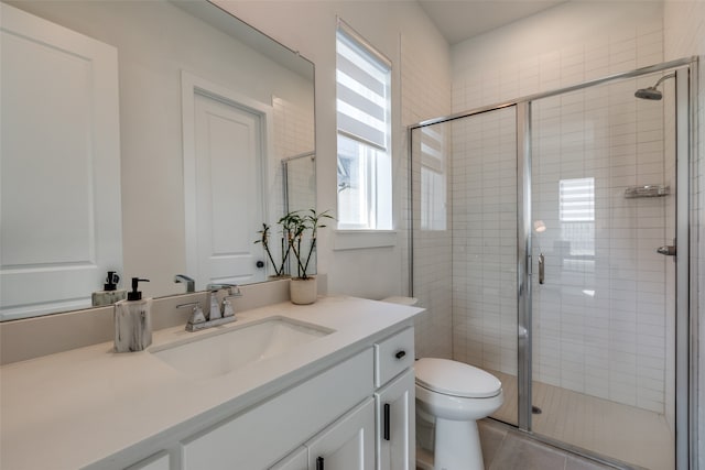 bathroom with tile patterned floors, vanity, toilet, and an enclosed shower