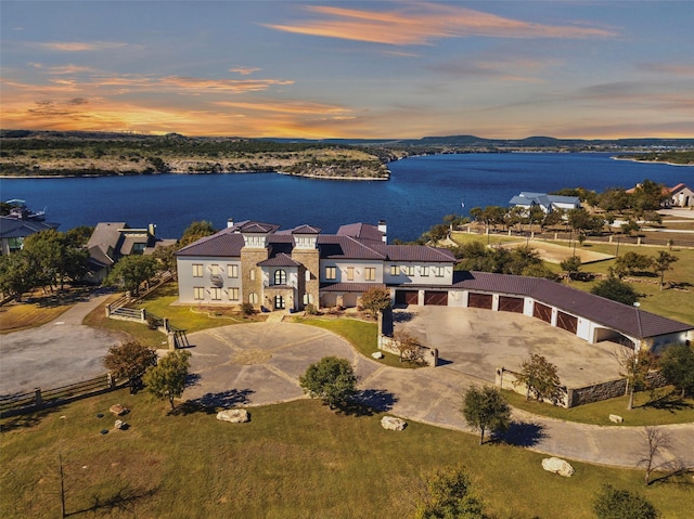 aerial view at dusk featuring a water view