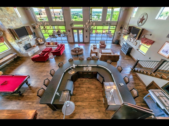 living room featuring a towering ceiling, hardwood / wood-style floors, and pool table