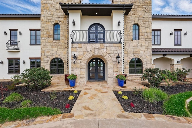 5101 Hells Gate Loop, Possum Kingdom Lake, TX 76475 - view of front of home featuring french doors, a balcony, stucco siding, stone siding, and a chimney