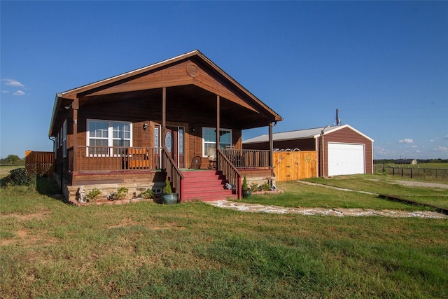 view of front of house featuring a porch, a garage, an outdoor structure, and a front lawn