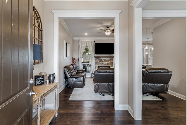 foyer entrance with crown molding, a fireplace, and dark wood-type flooring