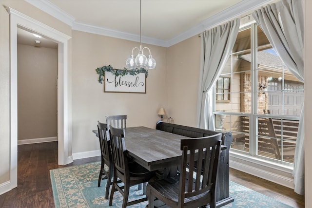 dining room with dark wood-type flooring, plenty of natural light, and crown molding