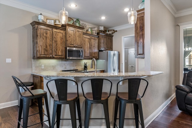 kitchen featuring crown molding, stainless steel appliances, kitchen peninsula, and backsplash