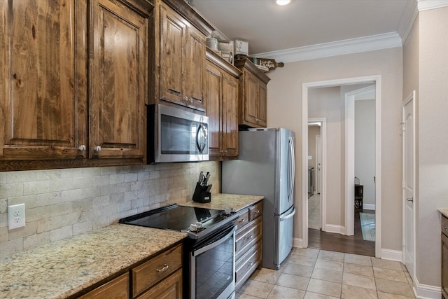 kitchen featuring tasteful backsplash, light tile patterned floors, light stone counters, stainless steel appliances, and crown molding