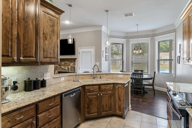 kitchen featuring appliances with stainless steel finishes, decorative light fixtures, light stone countertops, and sink