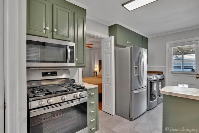 kitchen featuring washer and dryer, appliances with stainless steel finishes, green cabinetry, and crown molding