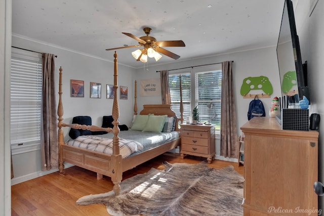 bedroom with light wood-type flooring, ceiling fan, and crown molding