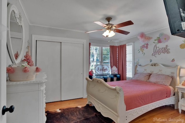 bedroom featuring hardwood / wood-style floors, ceiling fan, ornamental molding, and a closet