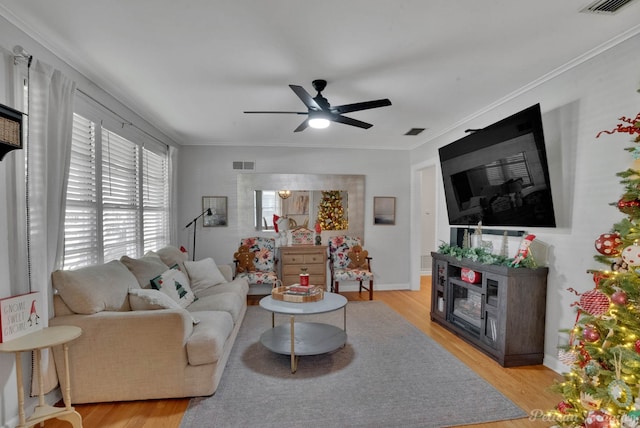 living room featuring ceiling fan, light hardwood / wood-style floors, and ornamental molding