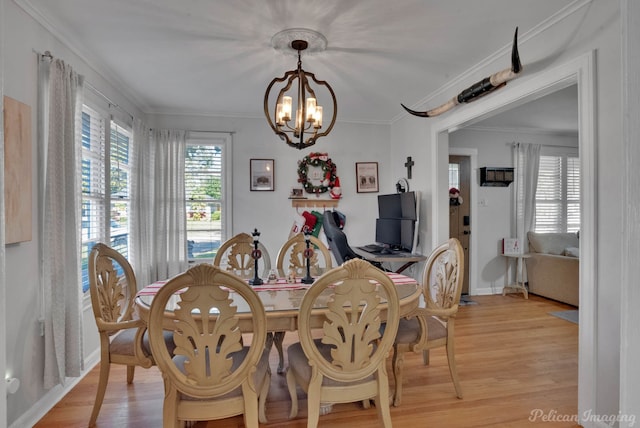 dining room featuring a chandelier, light hardwood / wood-style flooring, and crown molding