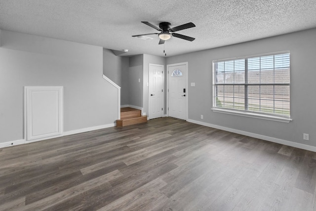 foyer entrance featuring a textured ceiling, ceiling fan, and dark wood-type flooring