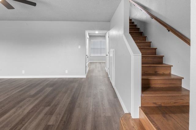 stairway featuring hardwood / wood-style flooring, ceiling fan, and a textured ceiling