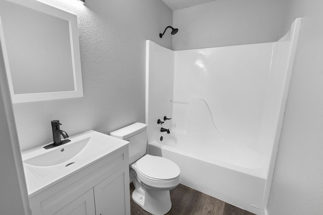 full bathroom featuring wood-type flooring, shower / washtub combination, vanity, and toilet