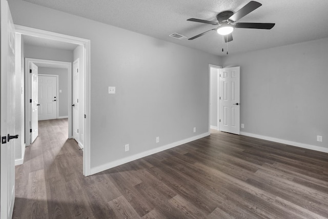 empty room featuring dark hardwood / wood-style floors, ceiling fan, and a textured ceiling