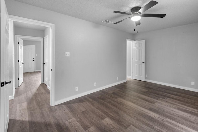 spare room with dark hardwood / wood-style flooring, ceiling fan, and a textured ceiling