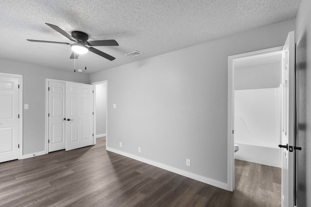 unfurnished bedroom with a textured ceiling, ceiling fan, and dark wood-type flooring