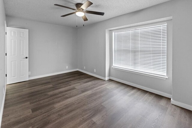 empty room featuring dark hardwood / wood-style floors, ceiling fan, and a textured ceiling