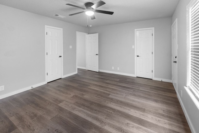 unfurnished bedroom featuring a textured ceiling, ceiling fan, and dark wood-type flooring