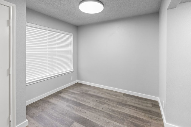 spare room featuring a textured ceiling and hardwood / wood-style flooring