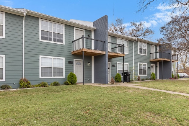 townhome / multi-family property with a balcony and a front yard