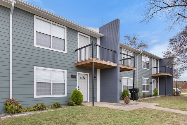 view of front of home featuring a balcony and a front yard