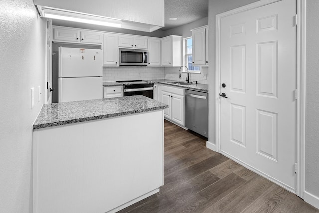 kitchen featuring appliances with stainless steel finishes, dark hardwood / wood-style flooring, sink, and white cabinets