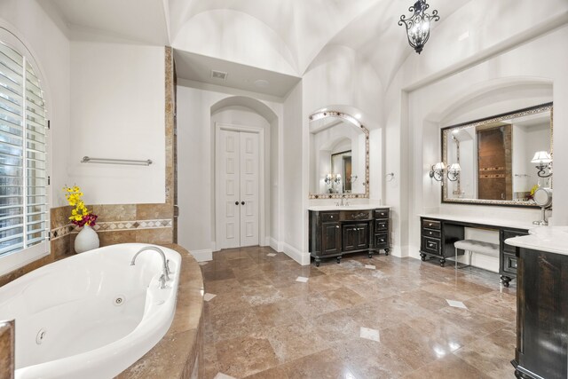 bathroom with vanity and a relaxing tiled tub