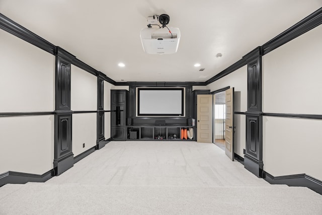 home theater room featuring light carpet and crown molding