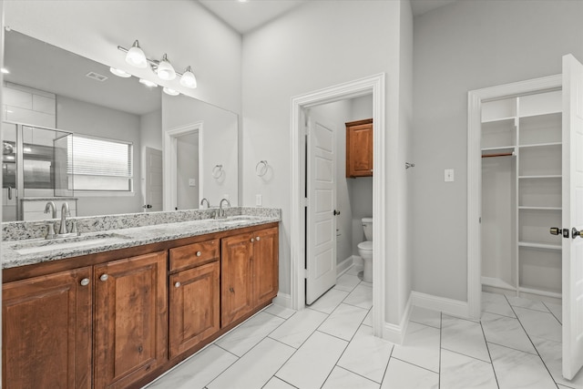 bathroom with vanity, a shower with shower door, and toilet