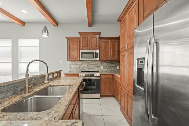 kitchen with light stone counters, sink, hanging light fixtures, and appliances with stainless steel finishes