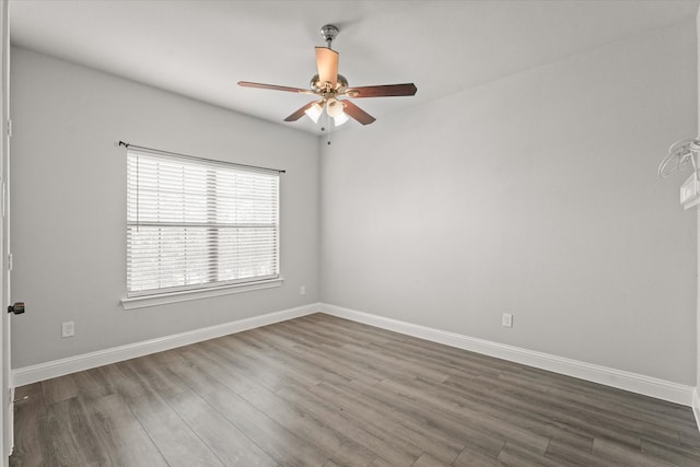 empty room with ceiling fan and dark hardwood / wood-style flooring