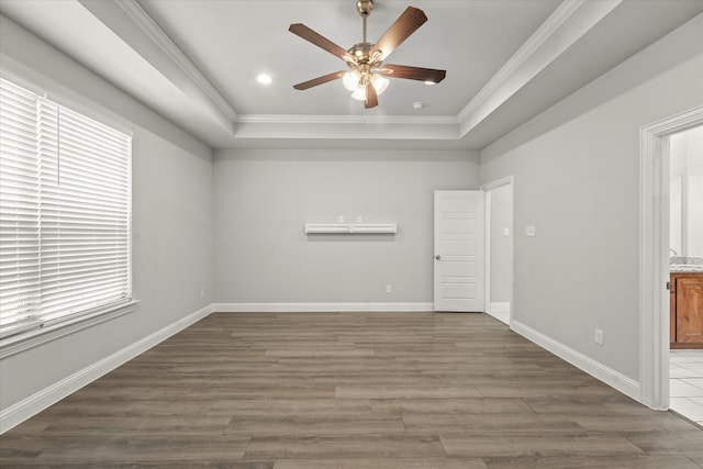 spare room featuring ornamental molding, a tray ceiling, and dark hardwood / wood-style flooring