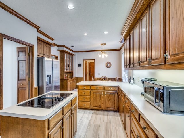 kitchen featuring a textured ceiling, kitchen peninsula, crown molding, and appliances with stainless steel finishes