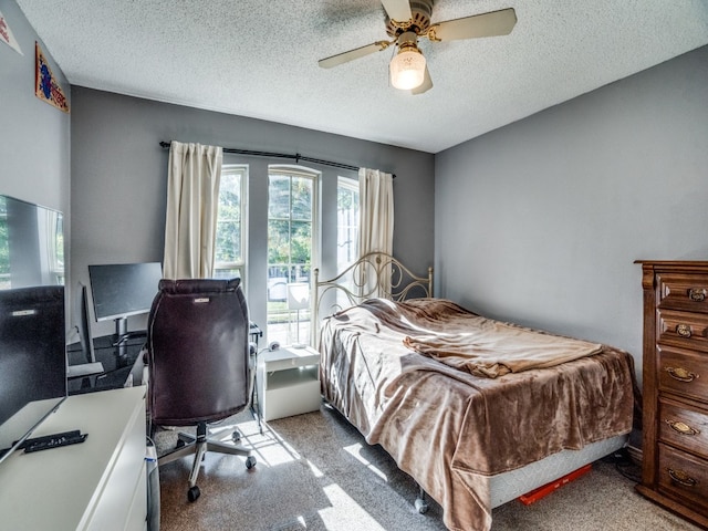 bedroom featuring ceiling fan, light colored carpet, and a textured ceiling