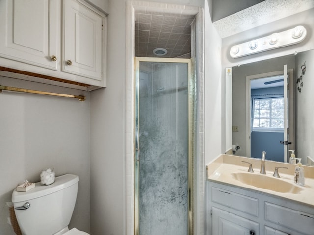 bathroom featuring vanity, toilet, and walk in shower