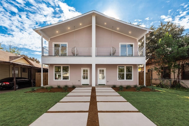 view of front of property featuring a balcony and a front lawn