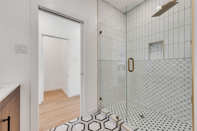 bathroom with hardwood / wood-style floors, vanity, and a shower with shower door