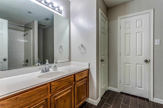 bathroom with vanity and tiled shower