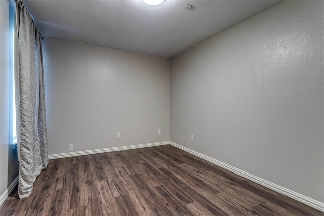 unfurnished room with dark wood-type flooring