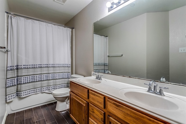 full bathroom featuring vanity, shower / tub combo, and toilet